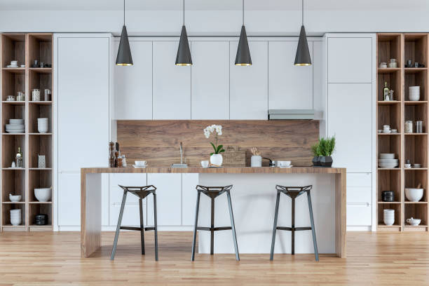 istock A front view of a modern white and hardwood kitchen with rectangular breakfast kitchen island with stools, pendant lights 2164902134