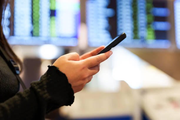 istock Hand using mobile phone checking Trip Destination online at airport. 2164903984