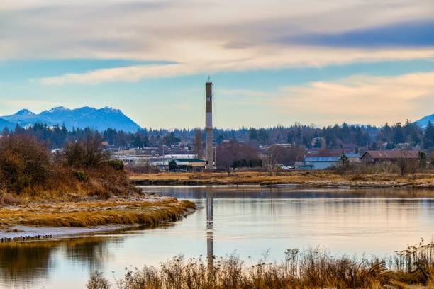 istock STILLAGUAMISH RIVER WINDING THROUGH STANWOOD WASHINGTON WITH A SMOKE STACK ANDBUILDINGS 2164921055
