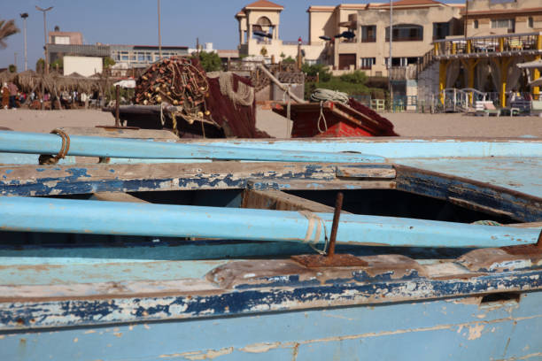 A lively and colorful view of traditional Egyptian felucca boats docked along the Nile River in Luxor, Egypt. Decorated with vibrant flags, fabric, and painted patterns, these boats are used for scenic river cruises and are an iconic part of Nile tourism. The clear blue sky and calm water reflect the charm of Egypt's cultural heritage and daily life along the riverbanks of one of the world’s most historic cities.