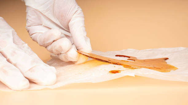 concentrated cannabis resin in hands, golden wax stock photo