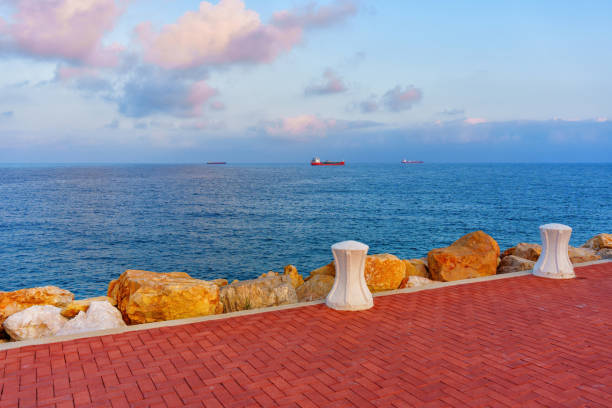 Charming view of the Tarragona waterfront featuring ships and rocky shoreline.
