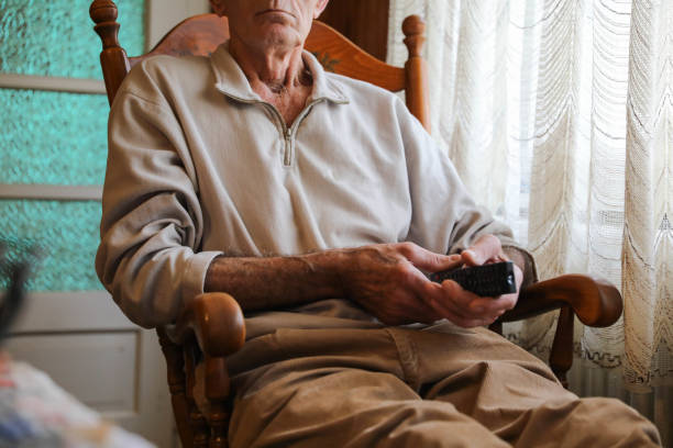 istock Close-Up of Elderly Man's Hands with TV Remote 2164935638