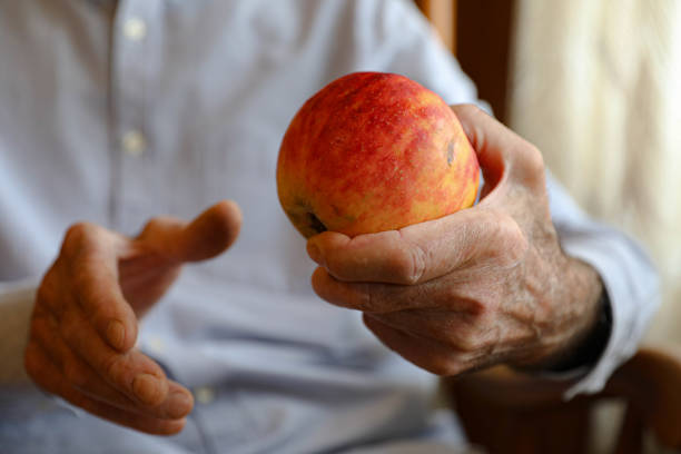 istock Elderly Man Holding a Red Apple 2164936093