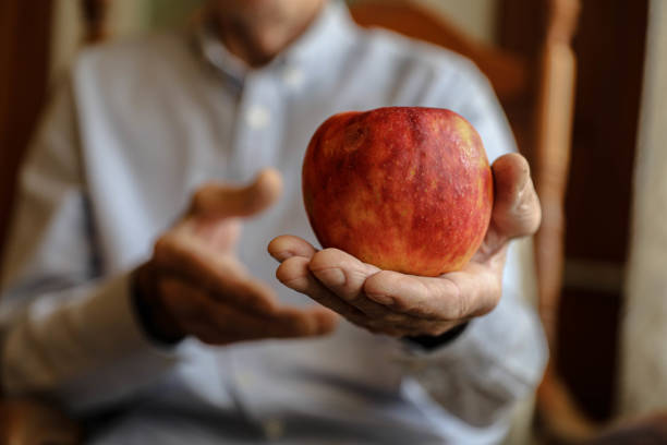 istock Elderly Hands Showcasing a Red Apple 2164936094