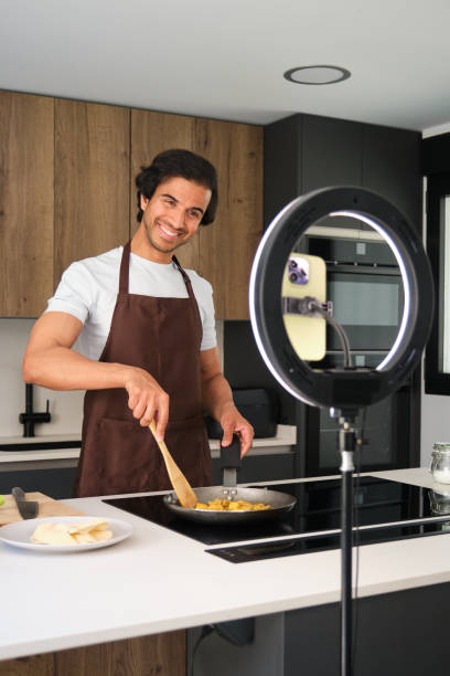 Indian food blogger cooking and recording video using ring light