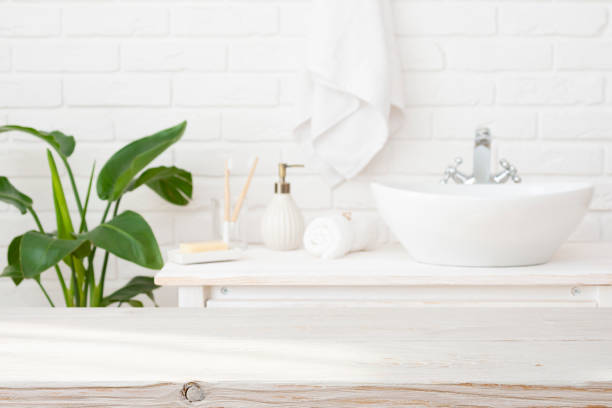 istock Blurred bathroom interior background with empty wooden table top for product montage 2164936842