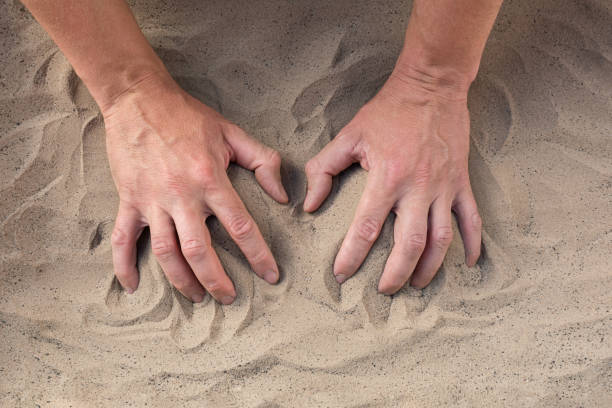 istock Despair in life. Hands touching the sand on the beach 2164939377