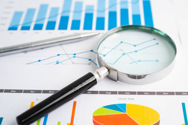 istock Magnifying glass on graph. Finance business and trading. 2164940040