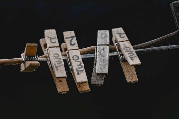 Five wooden clothespins hanging on a clothesline, each with the word 'two' written on them. A simple and rustic image, perfect for themes related to laundry, simplicity, or rustic living.