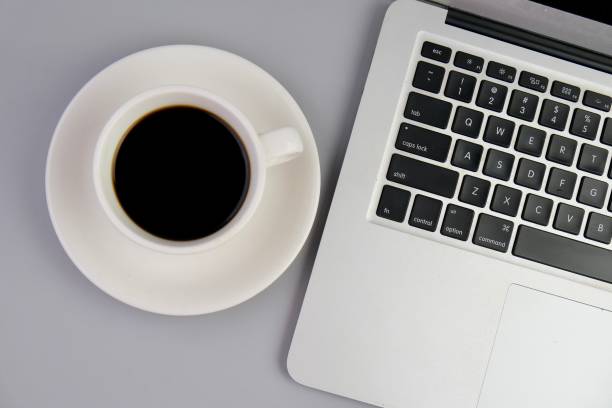 istock flat lay of a workplace with A cup of coffee, a laptop and a notebook, on a grey table. Education, business and office concept. 2164947084