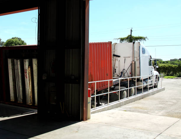 istock Commercial truck carrying cargo container parked by warehouse 2164952879