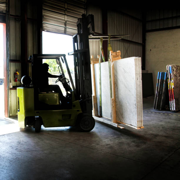 Forklift carrying granite slabs at warehouse