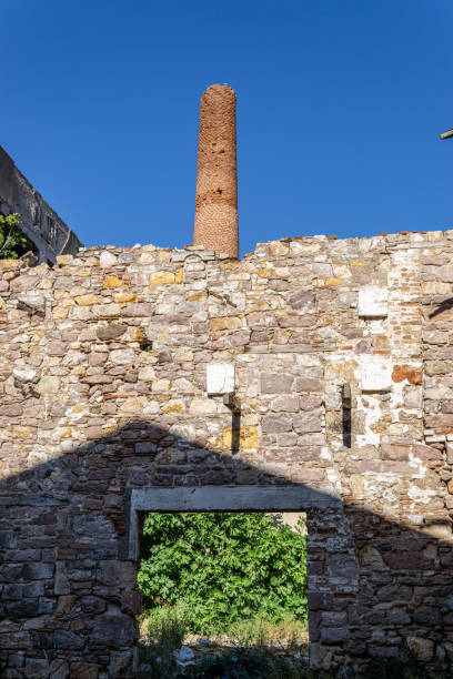 A shadowed wall and factory chimney
