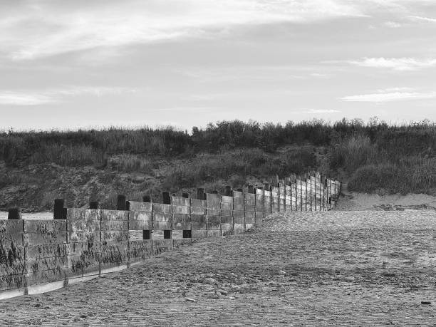 Railing sinking into the sand of San Lorenzo beach in Gijon