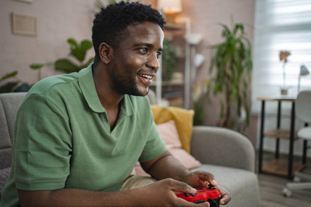 istock Young black man playing a video game at home 2164957878