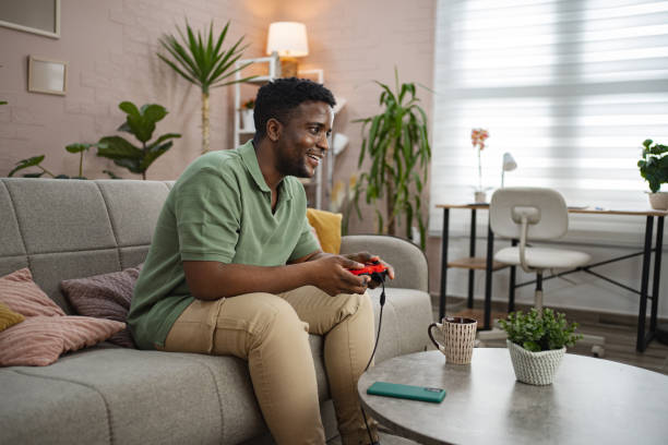 istock Young black man playing a video game at home 2164958295
