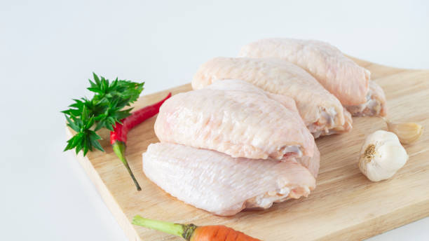 istock Raw chicken wings on a wooden cutting board 2164958367