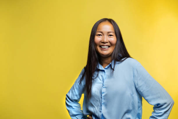 istock Happy woman on yellow background. 2164960953