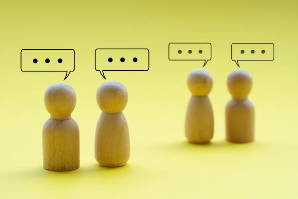istock Wooden figures talking to each other on yellow cover background representing networking or having business dealings 2164963857