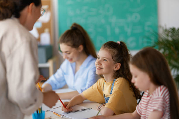 istock Happy kids and teacher at school 2164968492
