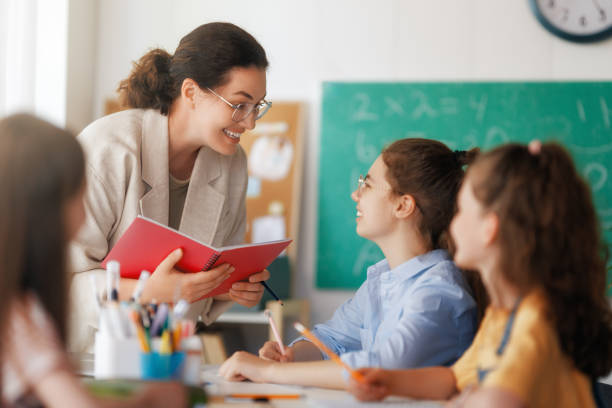 istock Happy kids and teacher at school 2164968536