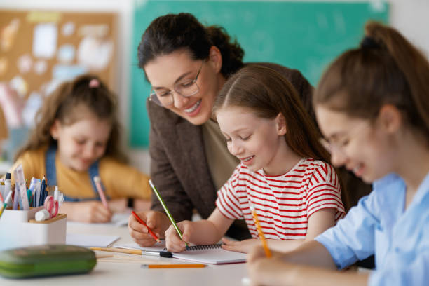 istock Happy kids and teacher at school 2164968539