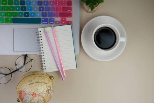 istock flatlay of a workplace with A cup of coffee, a laptop and a notebook, on a grey table. Education, business and office concept. 2164968559