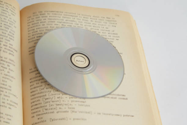 istock The CD-ROM lies on an open book page with text close-up, English language learning, educational courses, self-study, home education 2164968694