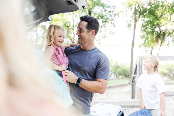 istock Dad smiles at daughter while son waits to finish unloading 2164968974