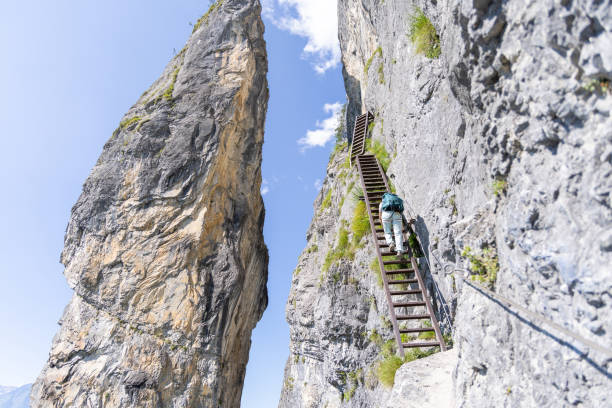 istock Climber ascending ladder on steep mountain trail 2164976809