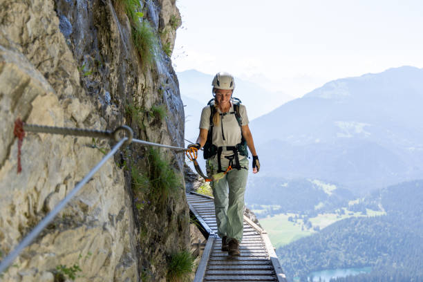 istock Climber on narrow elevated path with scenic mountain view, via ferrata 2164976838