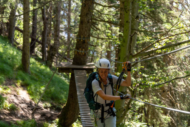 istock Female climber navigating suspension bridge in forest on a via ferrata 2164976913