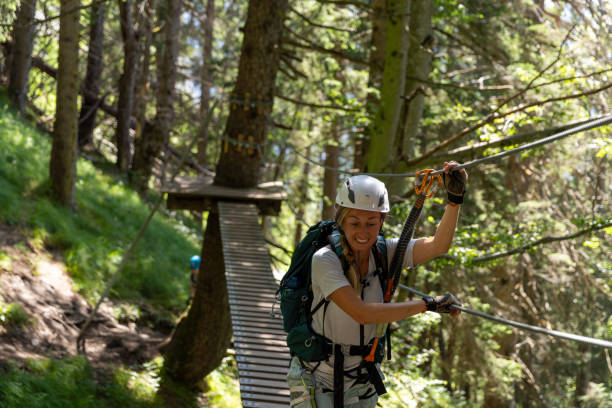 istock Female climber navigating suspension bridge in forest 2164976957