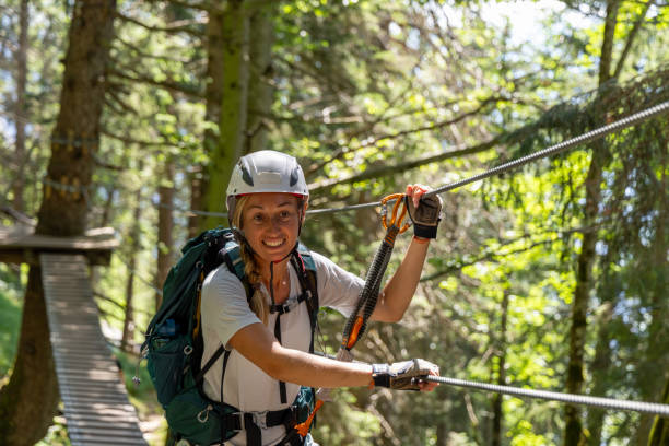 istock Female climber navigating suspension bridge in forest 2164976958