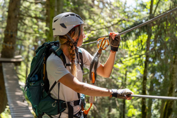 istock Via ferrata- Female climber navigating suspension bridge in forest 2164976963