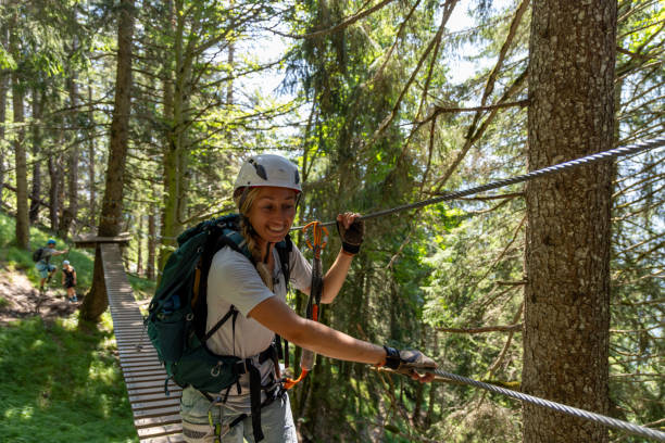 istock Female climber navigating suspension bridge in forest 2164977007