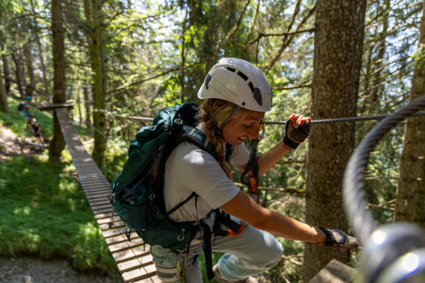 istock Female climber balancing on forest suspension bridge 2164977036