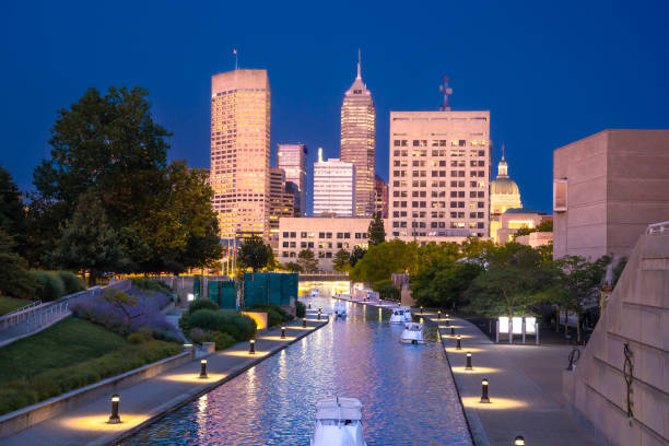 Indianapolis, Indiana skyline seen at night with buildings and canal walk in view.