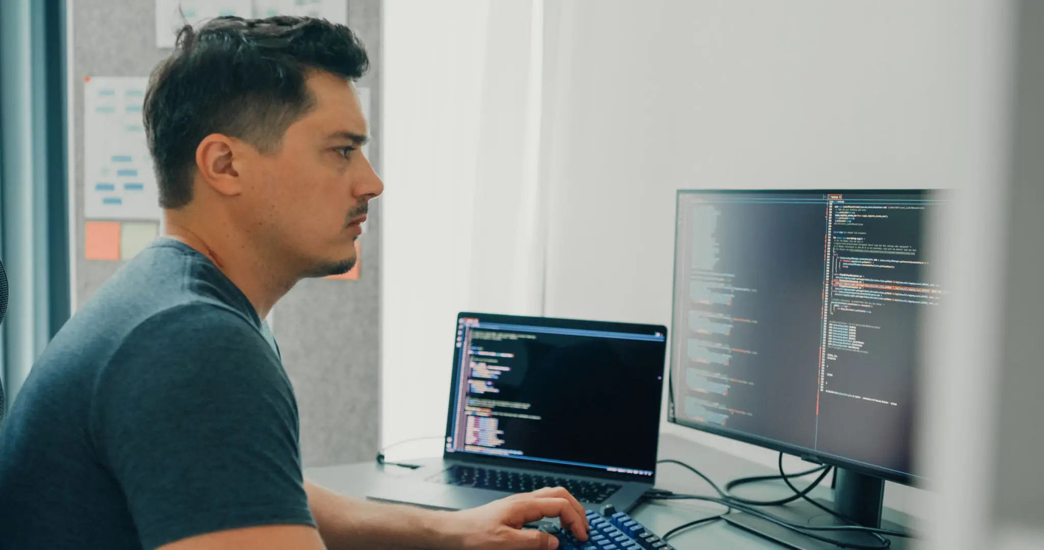 컴퓨터와 자바스크립트로 배우는 언어 프로그래밍 2 Young man software developers using computer to write code application program for AI technology development sitting at desk with multiple screens work at home office. Programmer development.