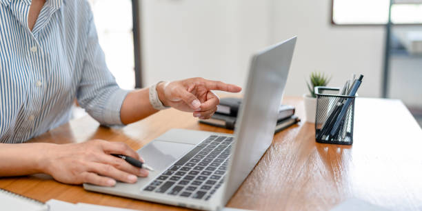 istock Hand holding pen pointing at laptop, online working corporate. 2164982105