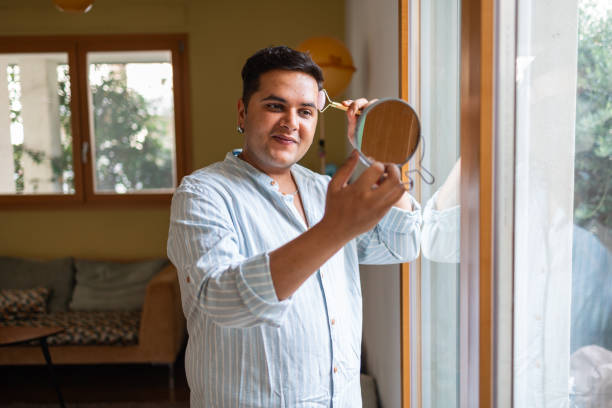 istock Man grooming in front of window using handheld mirror 2164985915