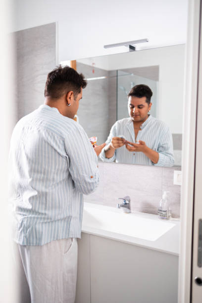 istock Man practicing morning skincare routine in modern bathroom 2164986041