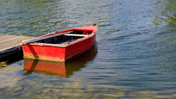 istock Red boat with oars at the pier. 2164990614