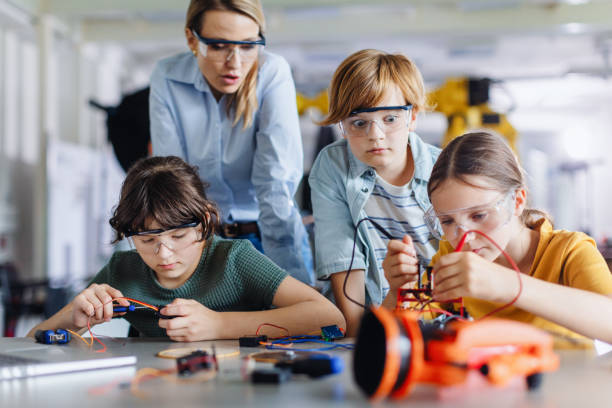 istock Children learning robotics in Elementary school. Young students building robot in after school robotics club. 2164995162