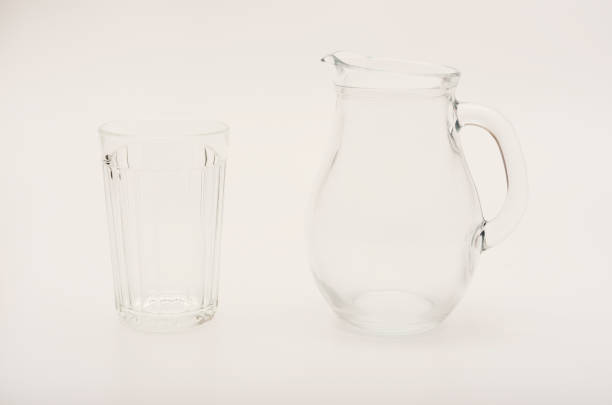 Glass jug and glass on a white background. Glassware.