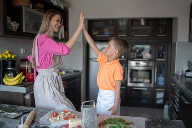 istock Mother and son looking happy cooking together making pizzas 2164998020