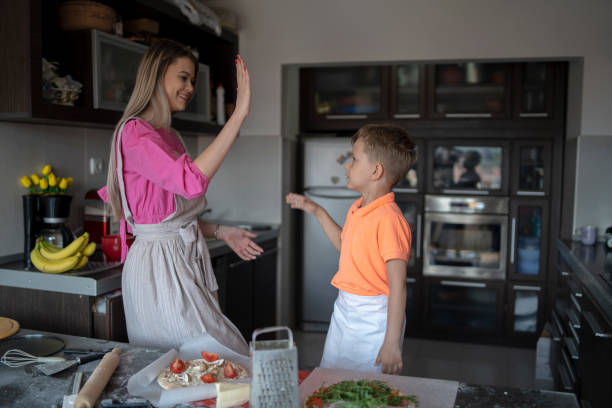 istock Mother and son looking happy cooking together making pizzas 2164998038