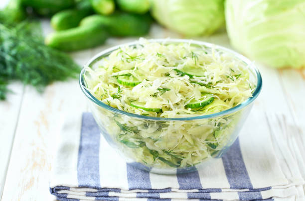 istock Bowl of spring vegan salad with cabbage, cucumber and dill on a white kitchen table, selective focus.Vegetarian salad. 2164998178