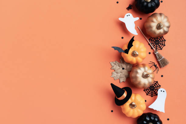 istock Halloween holiday frame with party decorations from pumpkins, bats, spider web and ghosts top view. Happy halloween greeting card on orange background. 2165003244